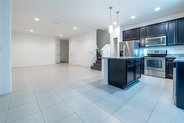 kitchen with light stone countertops, appliances with stainless steel finishes, light tile patterned floors, pendant lighting, and a center island