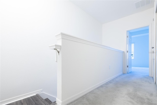 hallway featuring light colored carpet