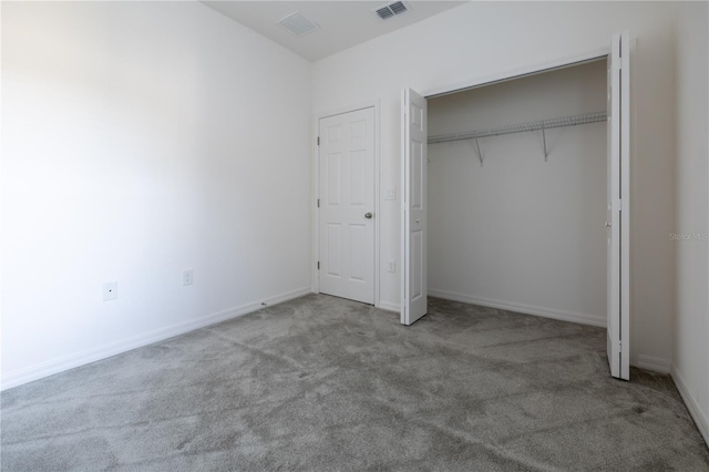 unfurnished bedroom featuring light carpet and a closet