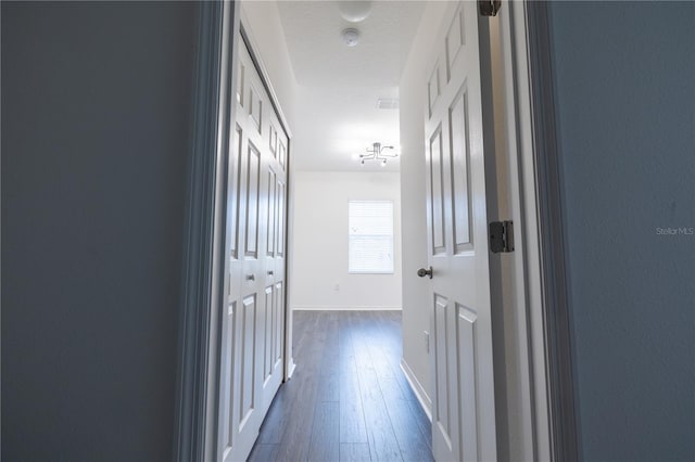 hallway with dark hardwood / wood-style flooring and a textured ceiling