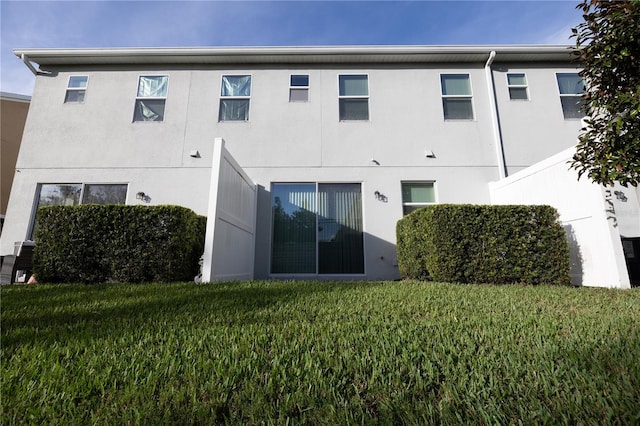 rear view of house featuring a lawn