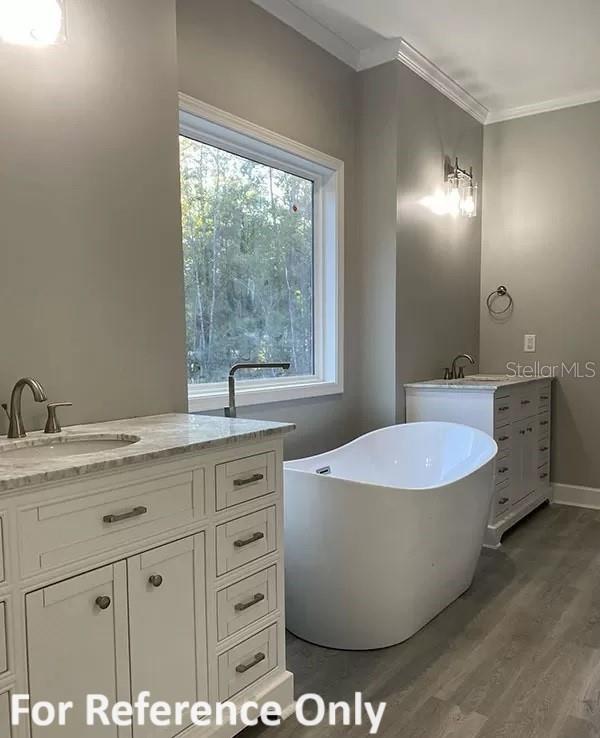 bathroom with wood-type flooring, vanity, a tub, and crown molding