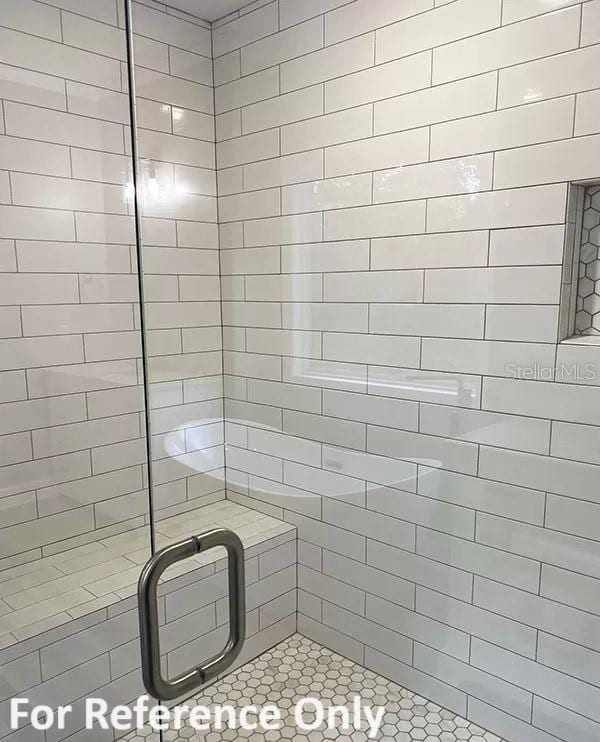 bathroom featuring a shower with door