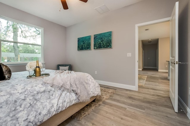 bedroom with ceiling fan, light wood-style flooring, and baseboards