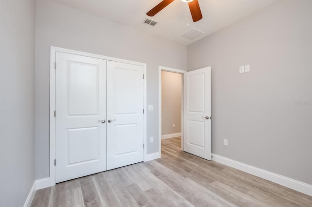 unfurnished bedroom featuring light wood-type flooring, baseboards, visible vents, and a closet