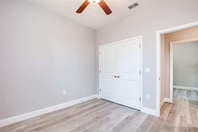 unfurnished bedroom featuring light wood-style flooring, a closet, visible vents, and baseboards