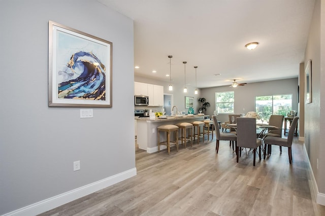 dining room featuring light wood-type flooring, ceiling fan, baseboards, and recessed lighting