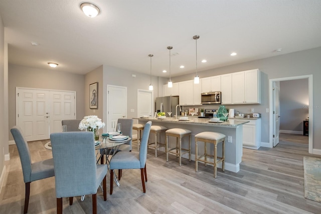 dining space with baseboards, recessed lighting, and light wood-style floors