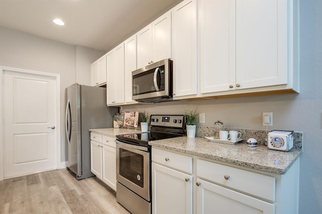 kitchen featuring light stone counters, stainless steel appliances, recessed lighting, light wood-style floors, and white cabinetry