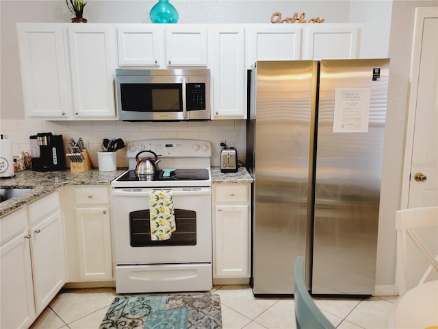 kitchen with decorative backsplash, white cabinetry, light tile patterned floors, and stainless steel appliances