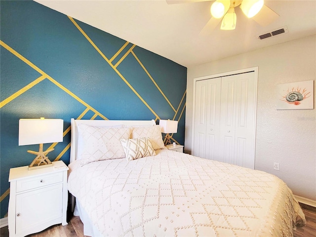 bedroom featuring ceiling fan, wood-type flooring, and a closet