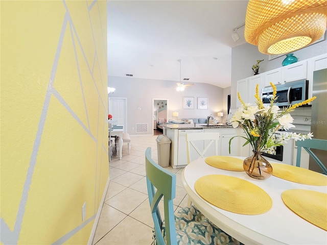 dining space with light tile patterned floors, vaulted ceiling, ceiling fan, and sink