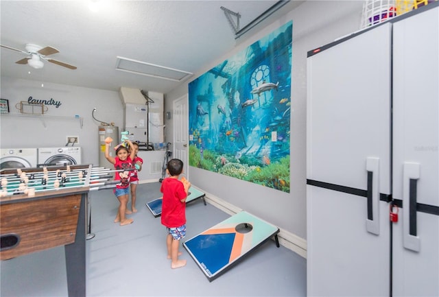 playroom with separate washer and dryer, ceiling fan, and water heater