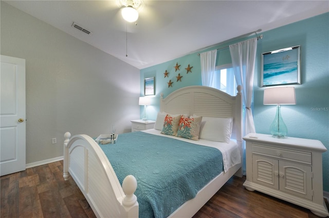 bedroom with dark hardwood / wood-style flooring, vaulted ceiling, and ceiling fan