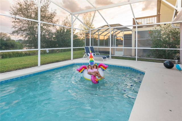 pool at dusk with a lanai and a patio