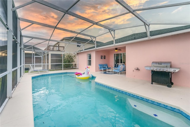 pool at dusk featuring glass enclosure, a patio area, and a grill