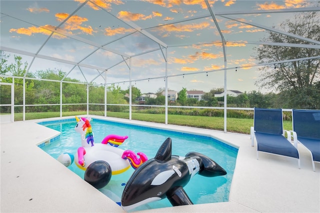 view of pool with a yard, a patio, and a lanai