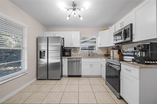 kitchen featuring light tile patterned flooring, appliances with stainless steel finishes, white cabinetry, and sink