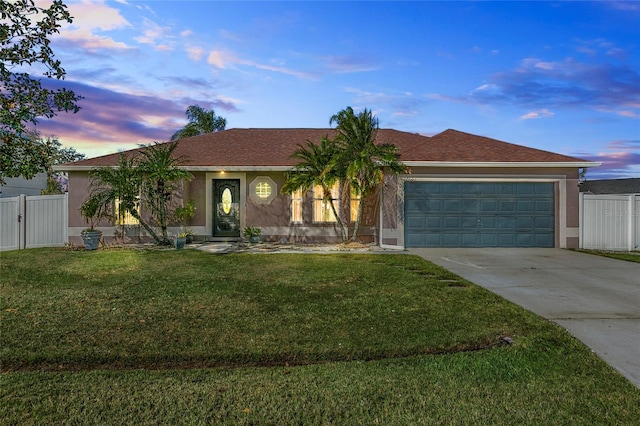 ranch-style house featuring a garage and a lawn