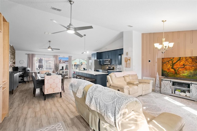 living room featuring ceiling fan with notable chandelier, light hardwood / wood-style floors, lofted ceiling, and sink