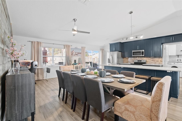 dining area with washer / dryer, light wood-type flooring, ceiling fan, and lofted ceiling