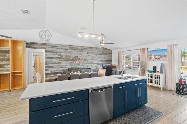 kitchen featuring stainless steel dishwasher, pendant lighting, a center island with sink, lofted ceiling, and wood walls