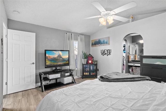 bedroom featuring a textured ceiling, ceiling fan, vaulted ceiling, and hardwood / wood-style flooring