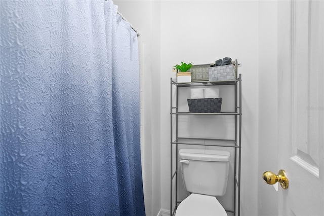 bathroom featuring walk in shower and toilet