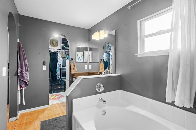 bathroom with tile patterned floors and a bath