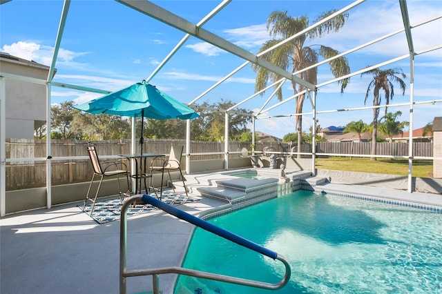 view of pool with glass enclosure and a patio area