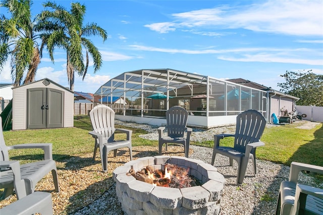 view of patio with glass enclosure, a fire pit, and a storage shed