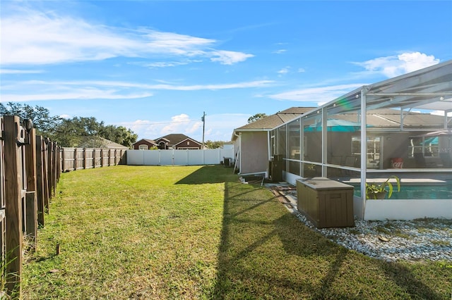 view of yard with glass enclosure and a fenced in pool