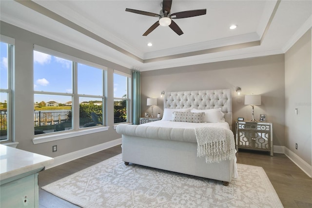 bedroom featuring baseboards, a raised ceiling, ornamental molding, wood finished floors, and recessed lighting