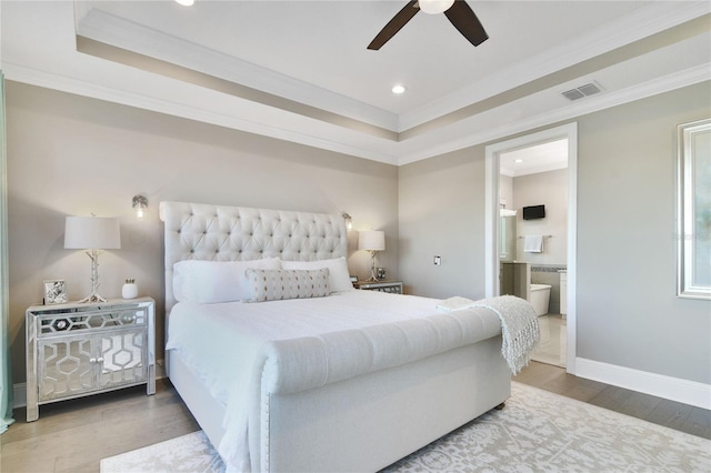 bedroom featuring a raised ceiling, wood finished floors, visible vents, and crown molding