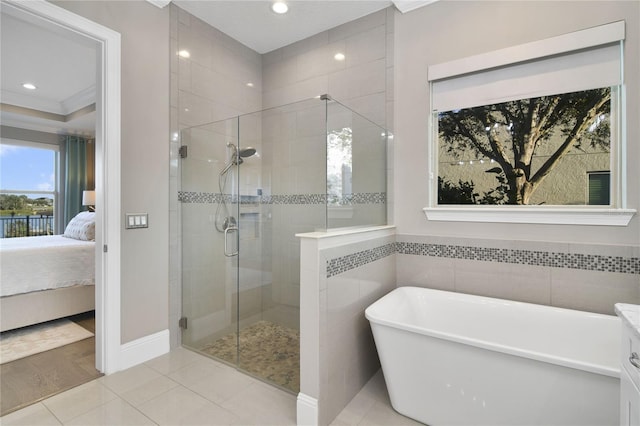 bathroom featuring a freestanding tub, a stall shower, tile patterned flooring, and ensuite bath