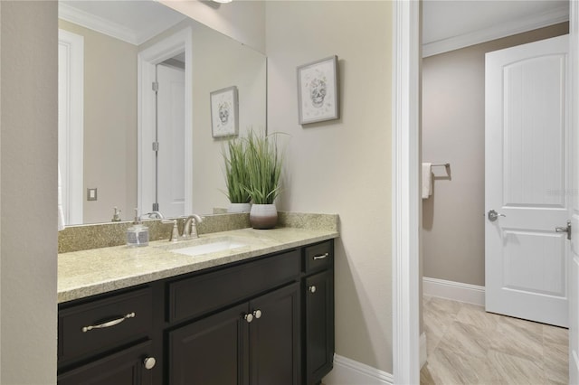 bathroom featuring ornamental molding, vanity, and baseboards