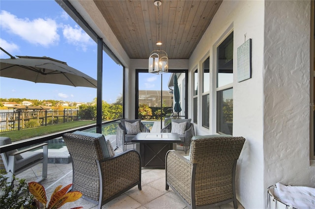 sunroom / solarium with wooden ceiling and an inviting chandelier