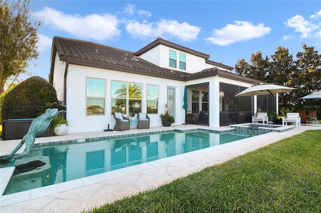 back of house with a patio, stucco siding, a lawn, a sunroom, and a tiled roof