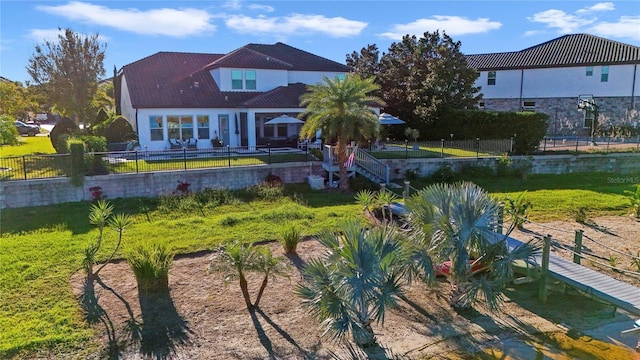 rear view of house featuring a fenced backyard and a yard