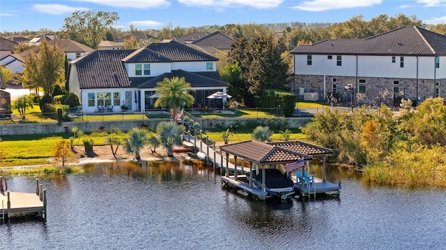 view of dock featuring a water view, boat lift, and a residential view