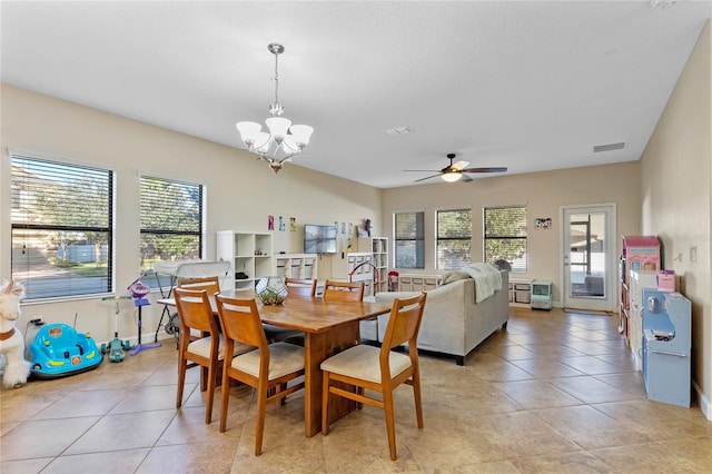 dining area featuring light tile patterned floors, a healthy amount of sunlight, and ceiling fan with notable chandelier