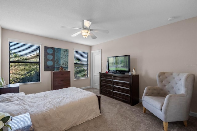 bedroom featuring light carpet, multiple windows, and ceiling fan