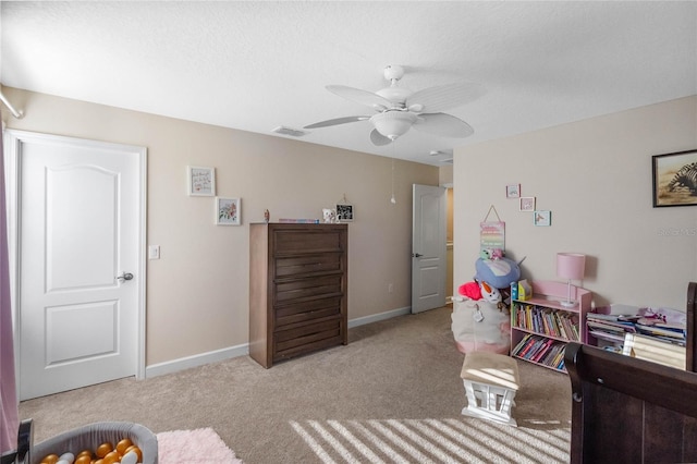 bedroom featuring light carpet, a textured ceiling, and ceiling fan