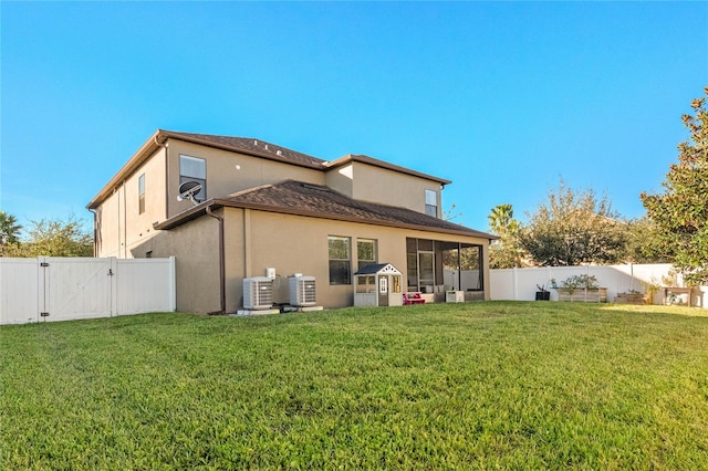 rear view of property featuring a sunroom, cooling unit, and a yard