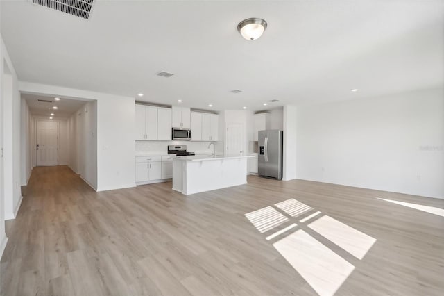 unfurnished living room featuring light hardwood / wood-style floors and sink