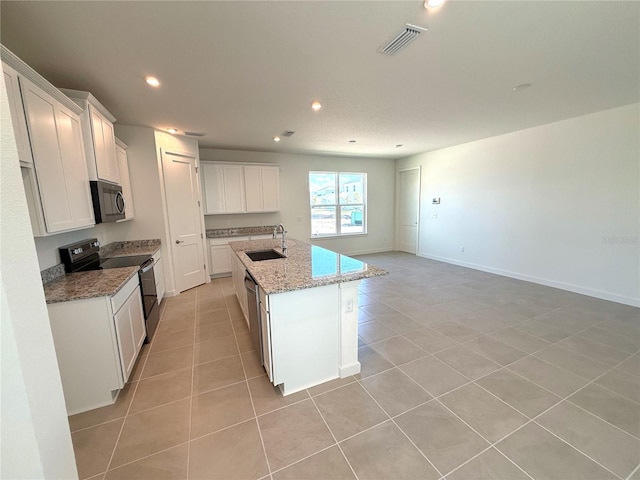 kitchen with white cabinets, sink, a center island with sink, black electric range oven, and light stone countertops