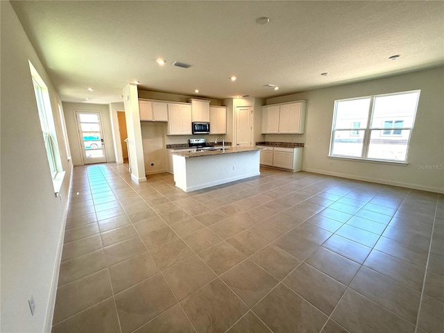 kitchen featuring light tile patterned floors, visible vents, white cabinetry, and stainless steel appliances