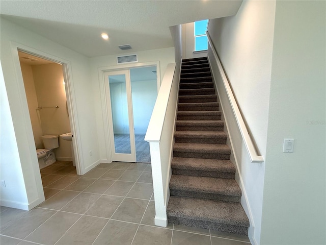 stairway featuring tile patterned flooring