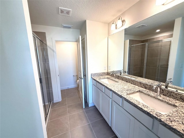 bathroom featuring tile patterned floors, an enclosed shower, vanity, a textured ceiling, and toilet