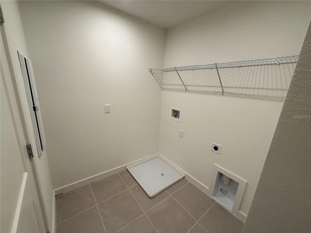 washroom featuring electric dryer hookup, dark tile patterned flooring, baseboards, hookup for a washing machine, and laundry area